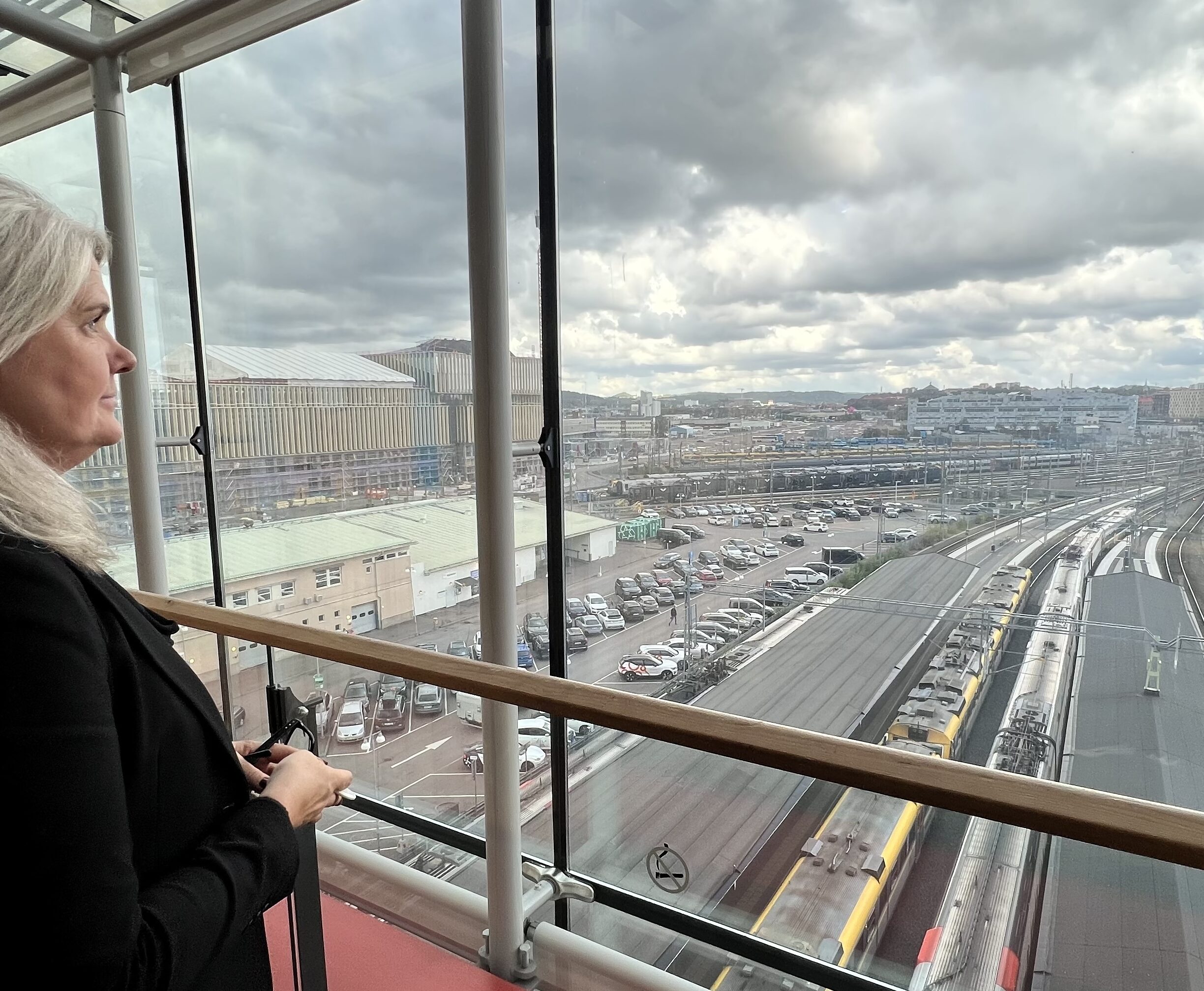 Nina Fors tittar ut över tågspåren som går precis utanför och delvis under hotellet.