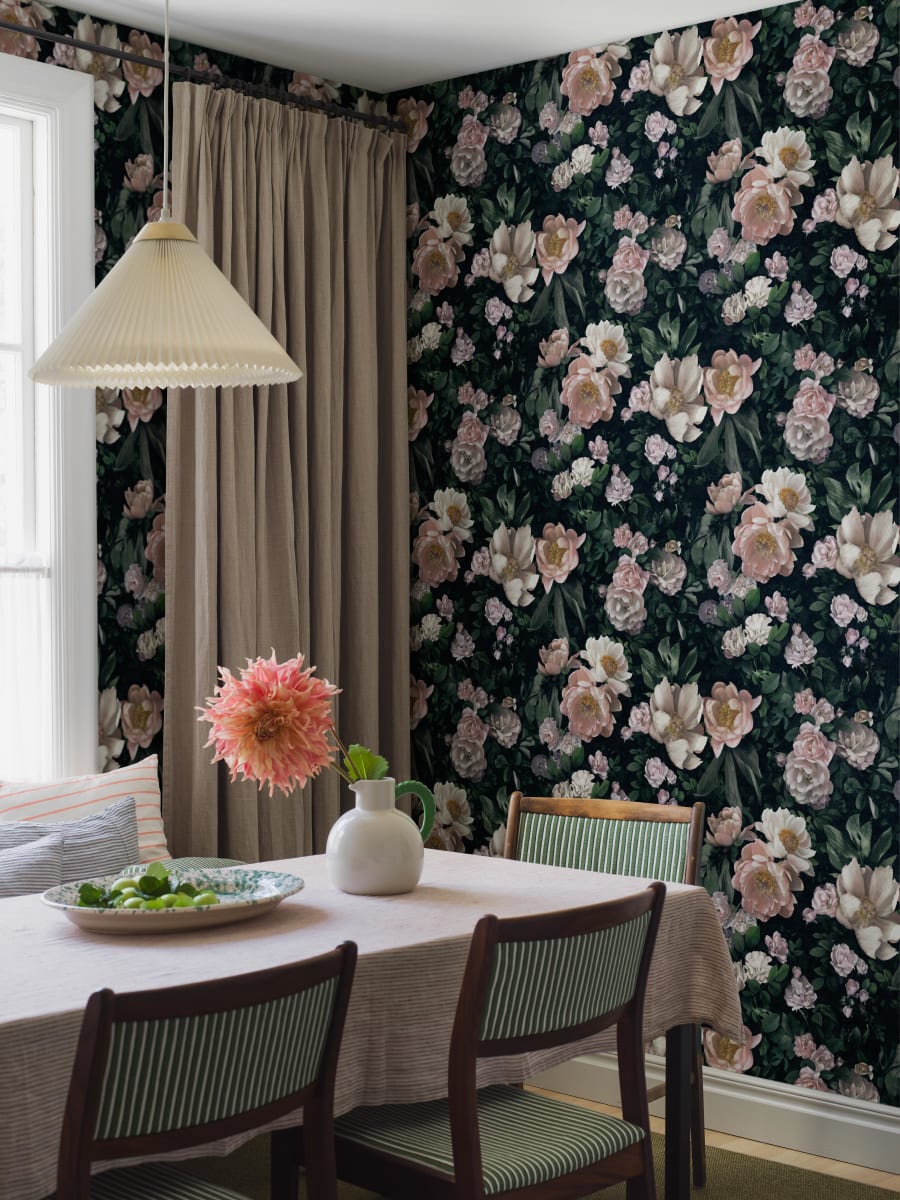 Med tapeten I New Dawn Rose står rosor i fokus, omgivna av pioner och suggestiv, frodig grönska. Det blommiga mönstret ger väggen ett levande och dekorativt uttryck.
