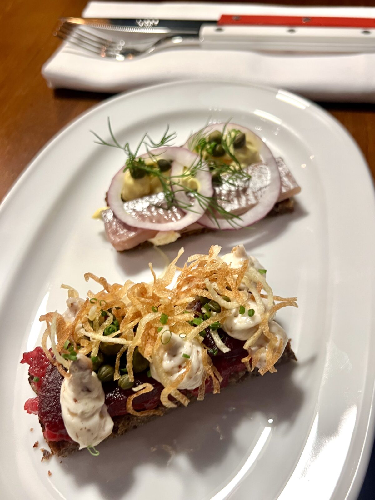 Oxtartar, betor, kapris, mandelemulsion, lökolja och frasig potatis på rågbröd samt matjesill, curry,  äggcreme och brynt smör på rågbröd.