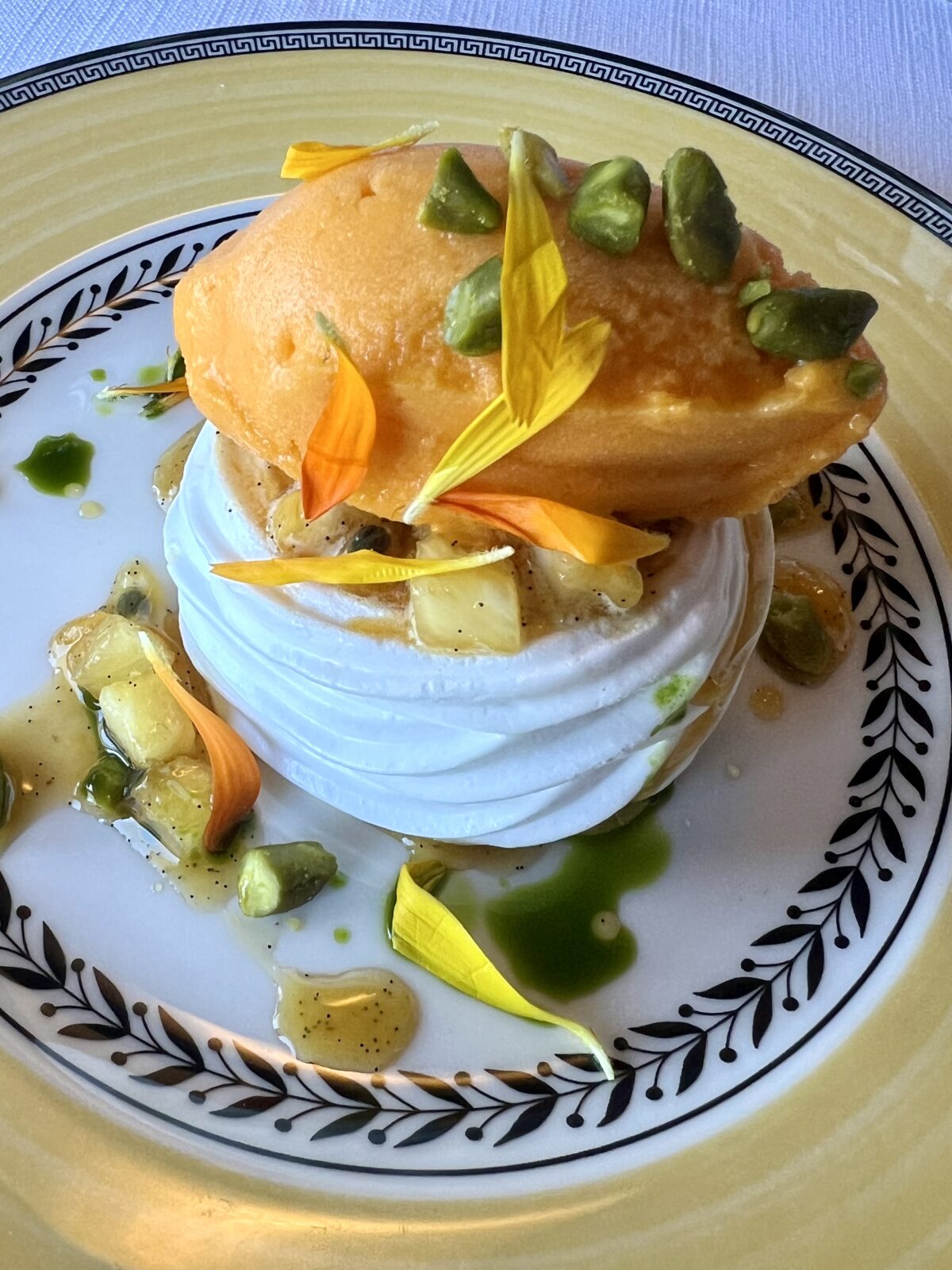 Pavlova till dessert med maräng och vaniljkräm, havtornssorbet, passionsfrukt, mango, ananas och pistage.